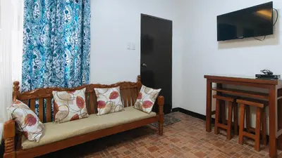 a couch with pillows and a television in a room at Alamaris Resort RedPartner in Rizal
