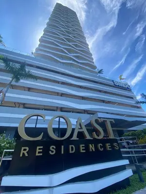 a tall building with a sign in front of it at SMDC Coast Residences near PICC World Trade Center MOA in Manila
