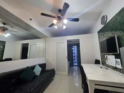 a living room with a couch and a ceiling fan at Sea Residences TowerE-F by EZStays in Manila