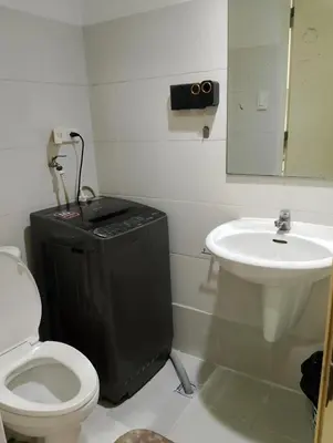 a bathroom with a toilet and a sink at Sea Residences TowerE-F by EZStays in Manila