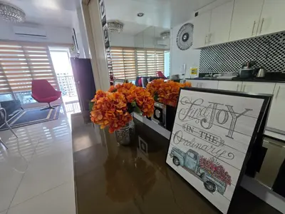 a kitchen with a counter with a sign and flowers at Sea Residences TowerE-F by EZStays in Manila