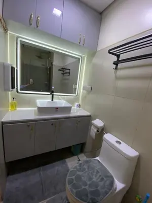 a bathroom with a sink and a toilet and a mirror at BayBreeze Haven Nest in Manila