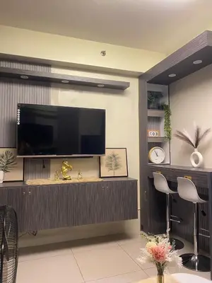 a living room with a flat screen tv on a wall at BayBreeze Haven Nest in Manila