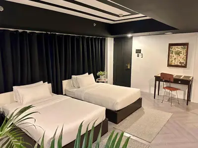 a hotel room with two beds and a desk at Havitat Boutique Hotel in Manila