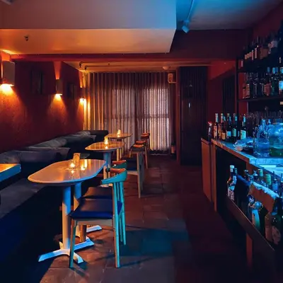 a bar with four tables and a couch in a room at Havitat Boutique Hotel in Manila