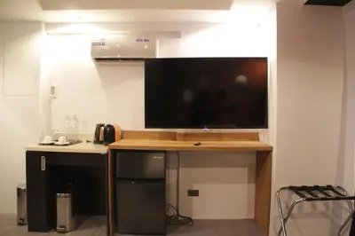 a large flat screen tv on a wall in a room at Havitat Boutique Hotel in Manila