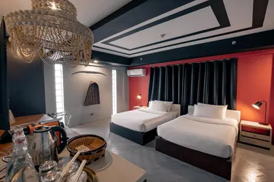 a hotel room with two beds and a chandelier at Havitat Boutique Hotel in Manila