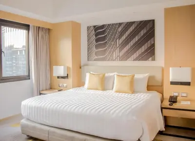 a bedroom with a large white bed with two tables and a window at Seda Bonifacio Global City Manila in Manila