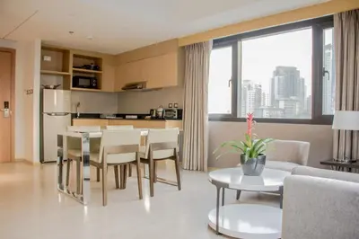a kitchen and living room with a table and chairs at Seda Bonifacio Global City Manila in Manila