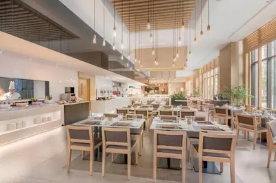 a restaurant with tables and chairs and a kitchen at Seda Bonifacio Global City Manila in Manila