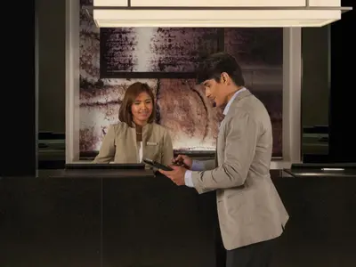 a man and a woman standing at a counter at Seda Bonifacio Global City Manila in Manila