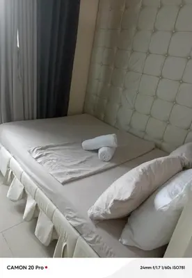 a bed with white sheets and pillows on it at MOA Rental in Manila