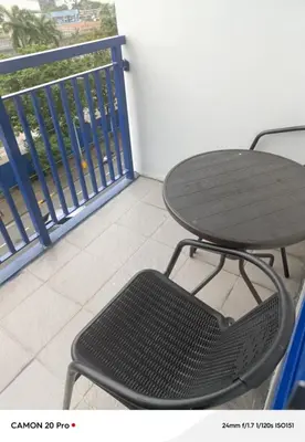 a table and chair sitting on a balcony at MOA Rental in Manila