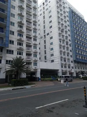 a large white building with a person walking in front of it at MOA Rental in Manila