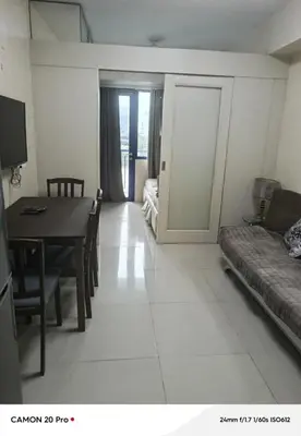 a living room with a table and a couch at MOA Rental in Manila