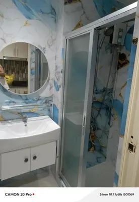 a bathroom with a shower and a sink and a mirror at MOA Rental in Manila