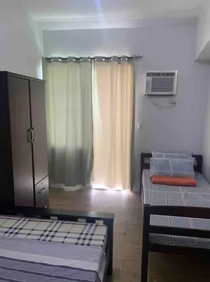 a room with two twin beds and a window at Lovely Spacious Condo With Balcony in Manila