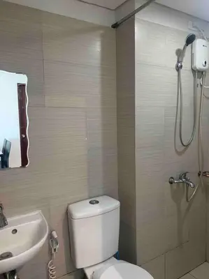 a bathroom with a shower and a toilet and a sink at Lovely Spacious Condo With Balcony in Manila