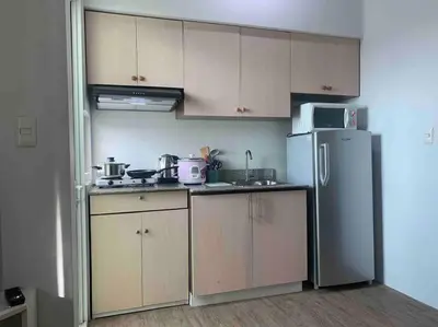 a kitchen with a refrigerator and a microwave at Lovely Spacious Condo With Balcony in Manila