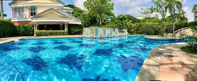 a swimming pool with blue water in front of a house at Pacific Residences Condo Del Juana Near BGC Taguig in Manila