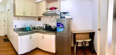 a kitchen with a stainless steel refrigerator and a stool at Pacific Residences Condo Del Juana Near BGC Taguig in Manila