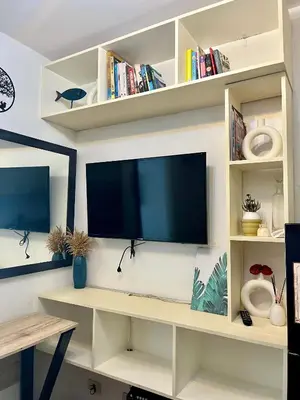 a living room with a tv on a shelf at Pacific Residences Condo Del Juana Near BGC Taguig in Manila
