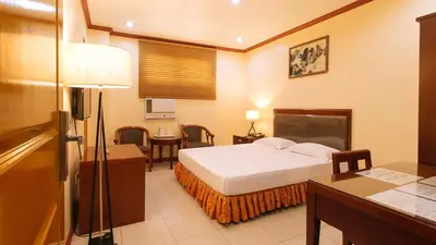 a hotel room with a bed and a desk and a room at Peace Hotel by RedDoorz in Manila