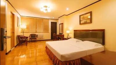 a hotel room with a bed and a table and chairs at Peace Hotel by RedDoorz in Manila