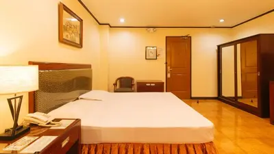 a bedroom with a bed and a desk with a phone at Peace Hotel by RedDoorz in Manila