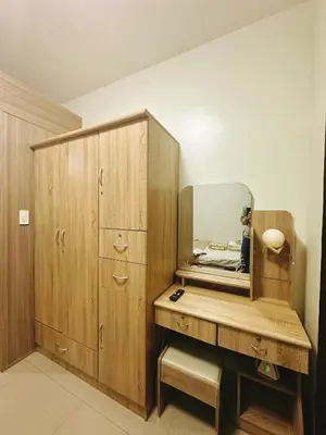a bedroom with a mirror and a wooden cabinet at Adel's Cosy Place - SMDC Shore 2 Philippines in Manila