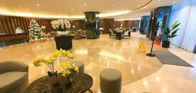a lobby with couches and tables and a christmas tree at Adel's Cosy Place - SMDC Shore 2 Philippines in Manila