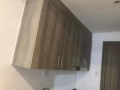 a kitchen with a wooden cabinet hanging from the ceiling at Condominium Fame Residence in Manila