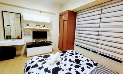 a bedroom with a cow print bed and a television at Cozy City View Condo @ Newport NAIA T3 Airport & RWM in Manila