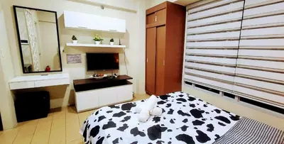 a bedroom with a cow print bed and a sink at Cozy City View Condo @ Newport NAIA T3 Airport & RWM in Manila