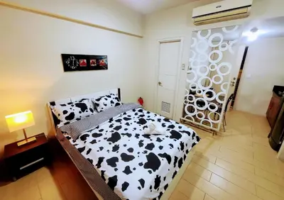 a bedroom with a black and white cow print bed at Cozy City View Condo @ Newport NAIA T3 Airport & RWM in Manila