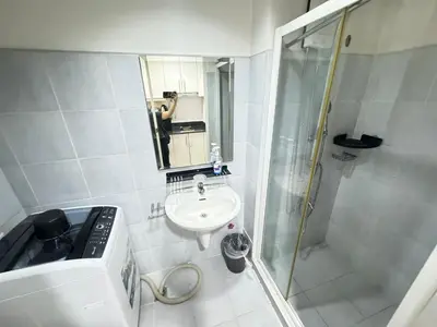 a person taking a picture of a bathroom with a sink and shower at Sea Residences by EXIN in Manila