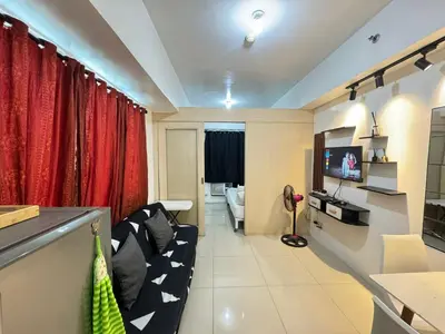 a living room with a couch and a television at Sea Residences by EXIN in Manila