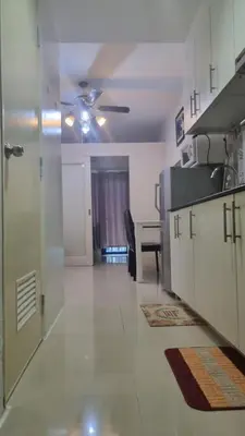a living room with a ceiling fan and a table at Sea Residences EZBedz in Manila