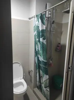 a bathroom with a toilet and a shower curtain at SMDC Coast Residences - Entire 1BR Condo with stunning view from 24th Floor in Manila