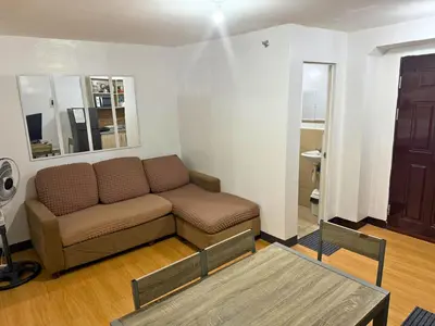 a living room with a couch and a table at 2-Bedroom Condo in Imus Cavite with UNLI WIFI, 50