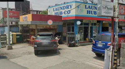 a car parked in a parking lot in front of shops at 2-Bedroom Condo in Imus Cavite with UNLI WIFI, 50