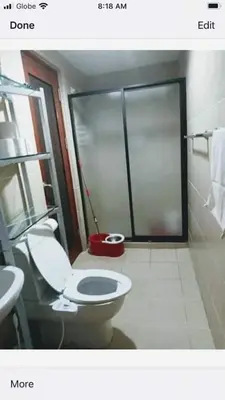 a bathroom with a toilet and a sink and a window at 16E 1 BR Mosaic staycation in Manila