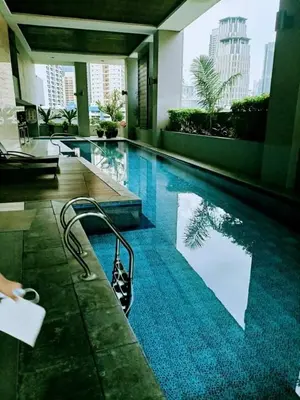 a large swimming pool in a building with a city at 16E 1 BR Mosaic staycation in Manila