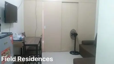 a living room with a room with a table and a door at Field Residences in Manila