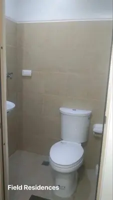 a bathroom with a toilet and a sink at Field Residences in Manila