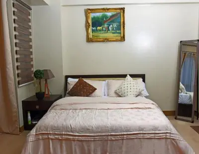 a bedroom with a bed and a picture on the wall at High-Rise Apartment Condo near NAIA Terminal 3 with a Perfect Airport Front-View in Manila