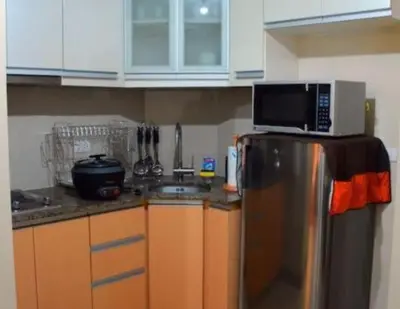a kitchen with a microwave on top of a refrigerator at High-Rise Apartment Condo near NAIA Terminal 3 with a Perfect Airport Front-View in Manila