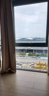 an airport window with a view of an airport runway at High-Rise Apartment Condo near NAIA Terminal 3 with a Perfect Airport Front-View in Manila