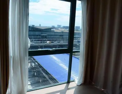 a room with a window with a view of an airport at High-Rise Apartment Condo near NAIA Terminal 3 with a Perfect Airport Front-View in Manila