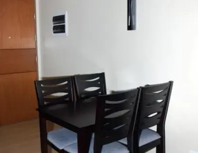 a black table with two chairs and a refrigerator at High-Rise Apartment Condo near NAIA Terminal 3 with a Perfect Airport Front-View in Manila